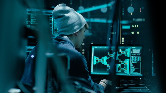 Back View of Teenage Hacker Working in Computer and Infecting wi